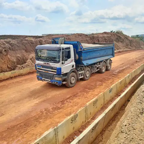 Tipper truck driving on a laterite road that has been laid out
